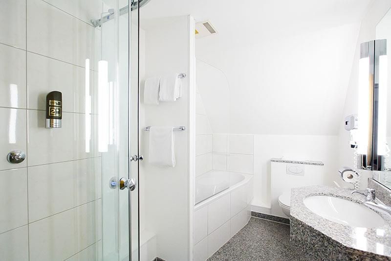 Ein Badezimmer mit Waschbecken, Badewanne, Dusche und Spiegel.