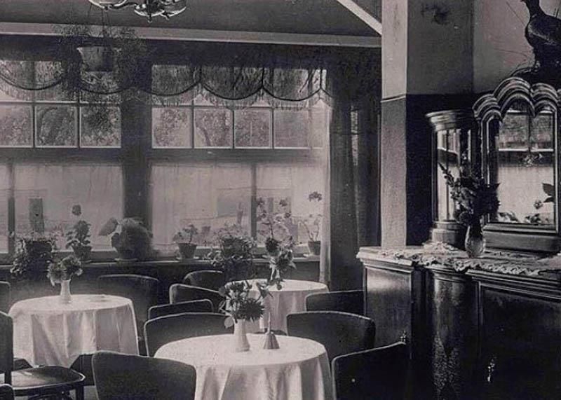 Ein Schwarzweißfoto eines Restaurants mit Tischen und Stühlen