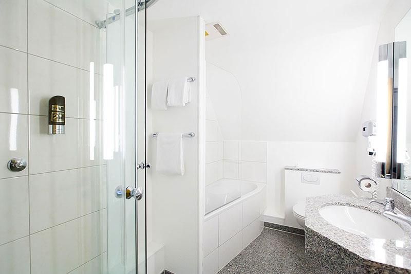 Ein Badezimmer mit Waschbecken, Badewanne, Dusche und Spiegel.