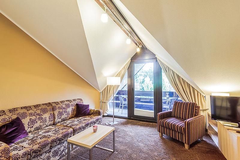 Ein Wohnzimmer mit einer Couch, einem Sessel und einem Tisch