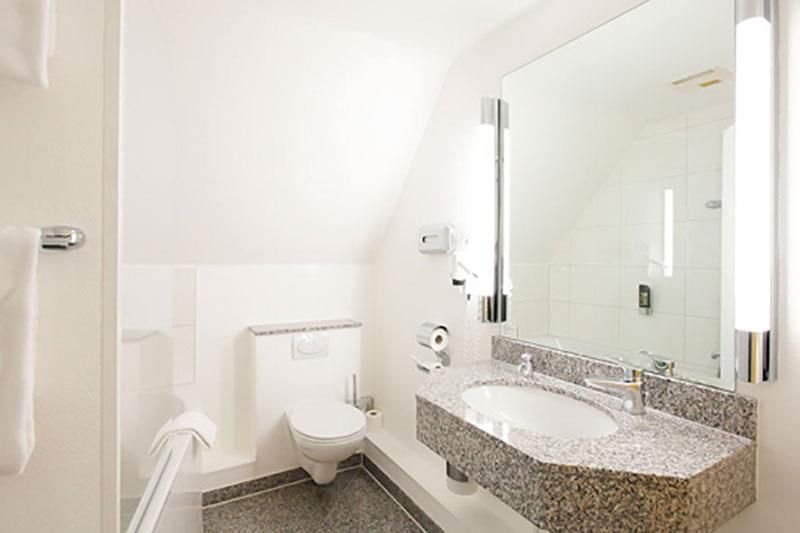 Ein Badezimmer mit Toilette, Waschbecken und Spiegel.