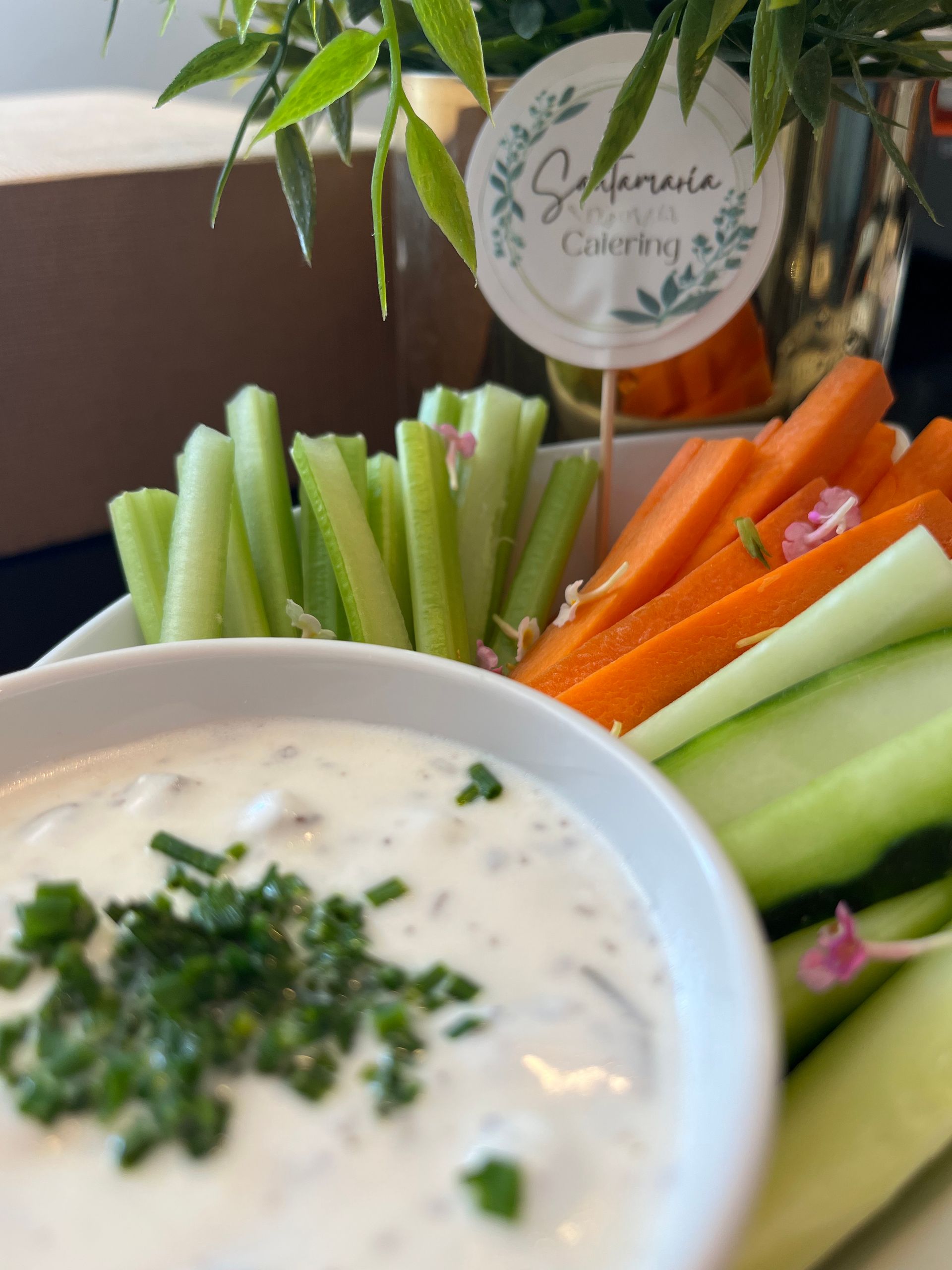 Crudités de verduras con salsa: apio, zanahoria, pepino y salsa blanca adornada con cebollino.