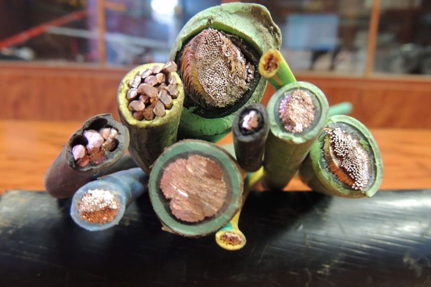 Un montón de diferentes tipos de cables están apilados uno encima del otro sobre una mesa.