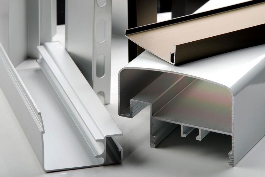 Un montón de diferentes tipos de perfiles de aluminio sobre una mesa.