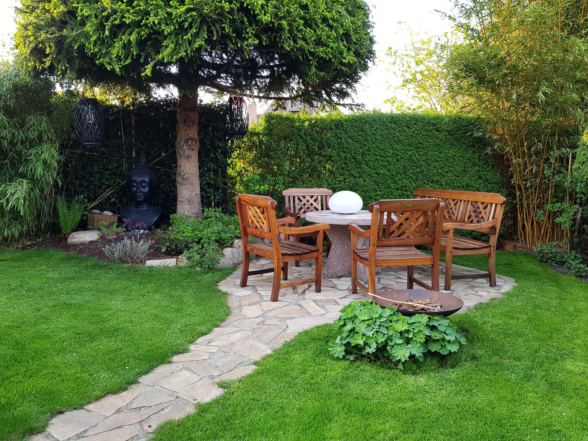 Un salon de jardin à côté d'une haie