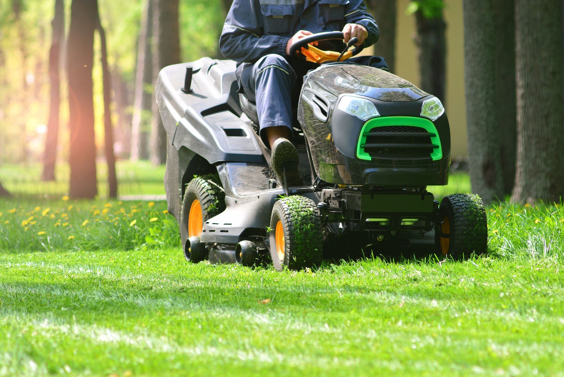 Un homme qui tond une pelouse avec un tracteur-tondeuse