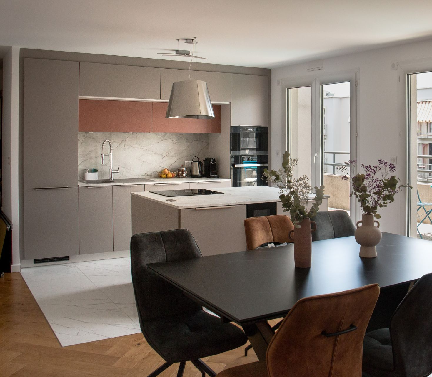 Une cuisine ouverte sur une salle à manger avec une table et des chaises.