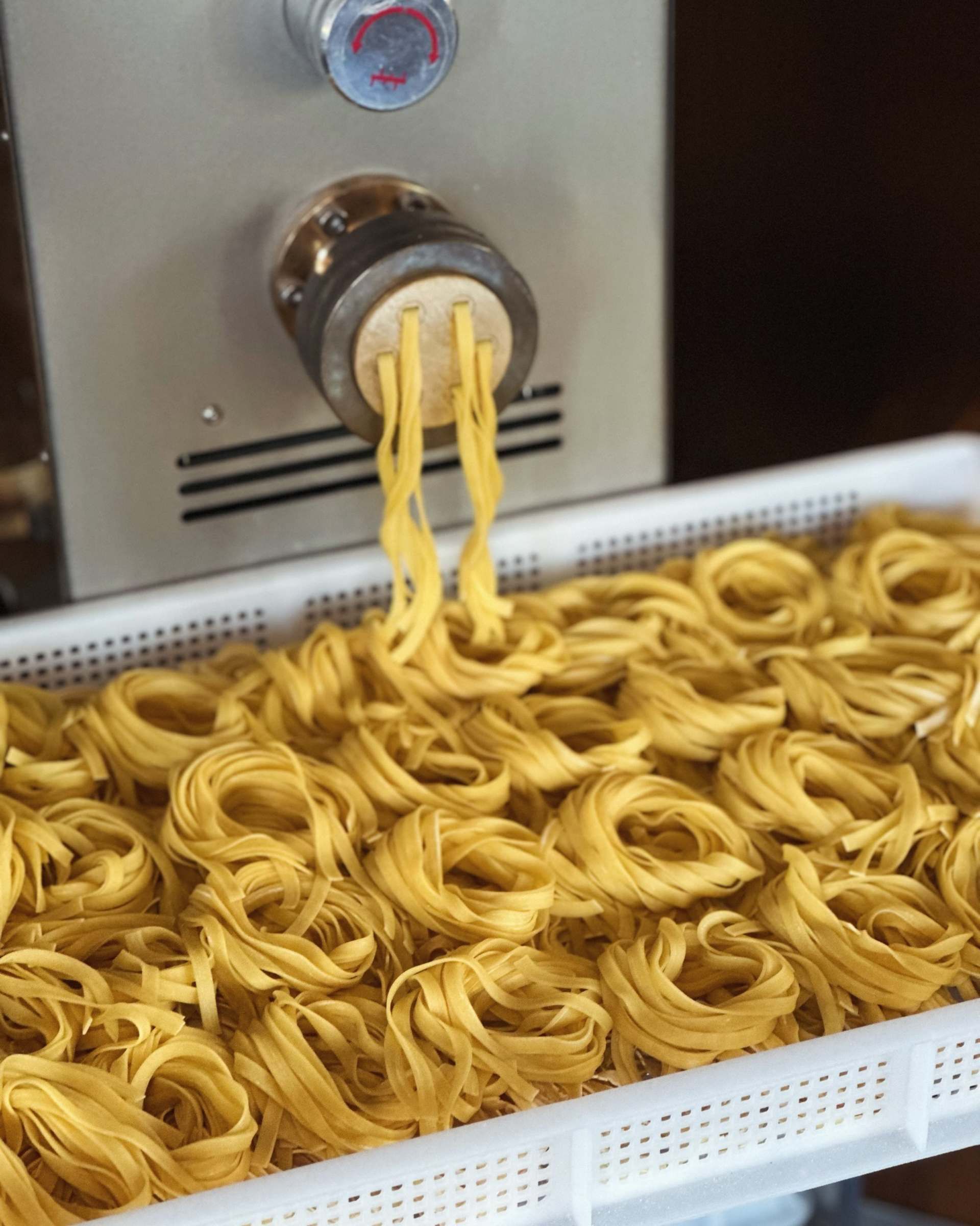 Eine Maschine stellt Pasta her. Foto von Zum Freihof Ristorante Pizzeria