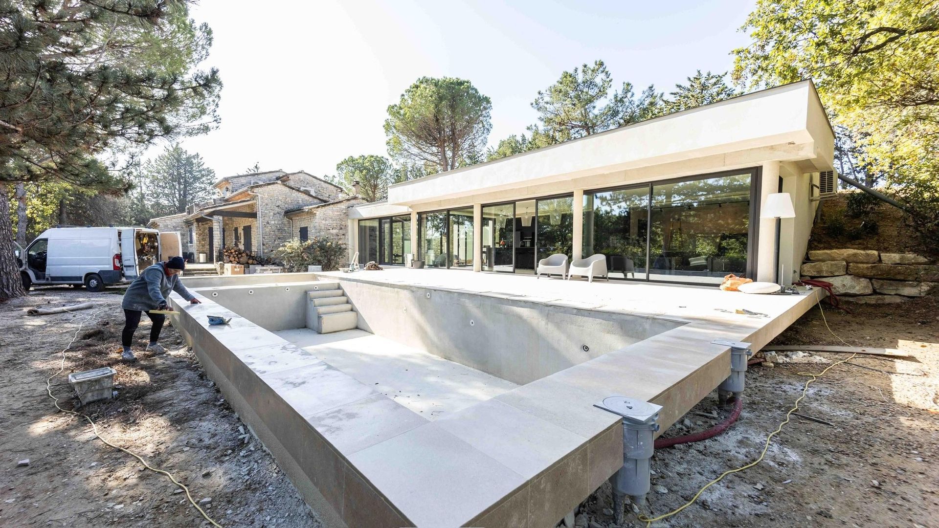 Vaste baie vitrée panoramique en aluminium et piscine en cours de construction.