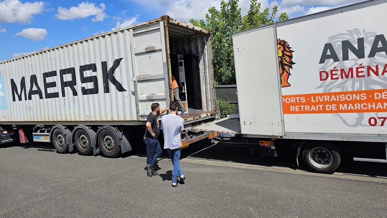 Deux hommes devant deux camions de déménagement
