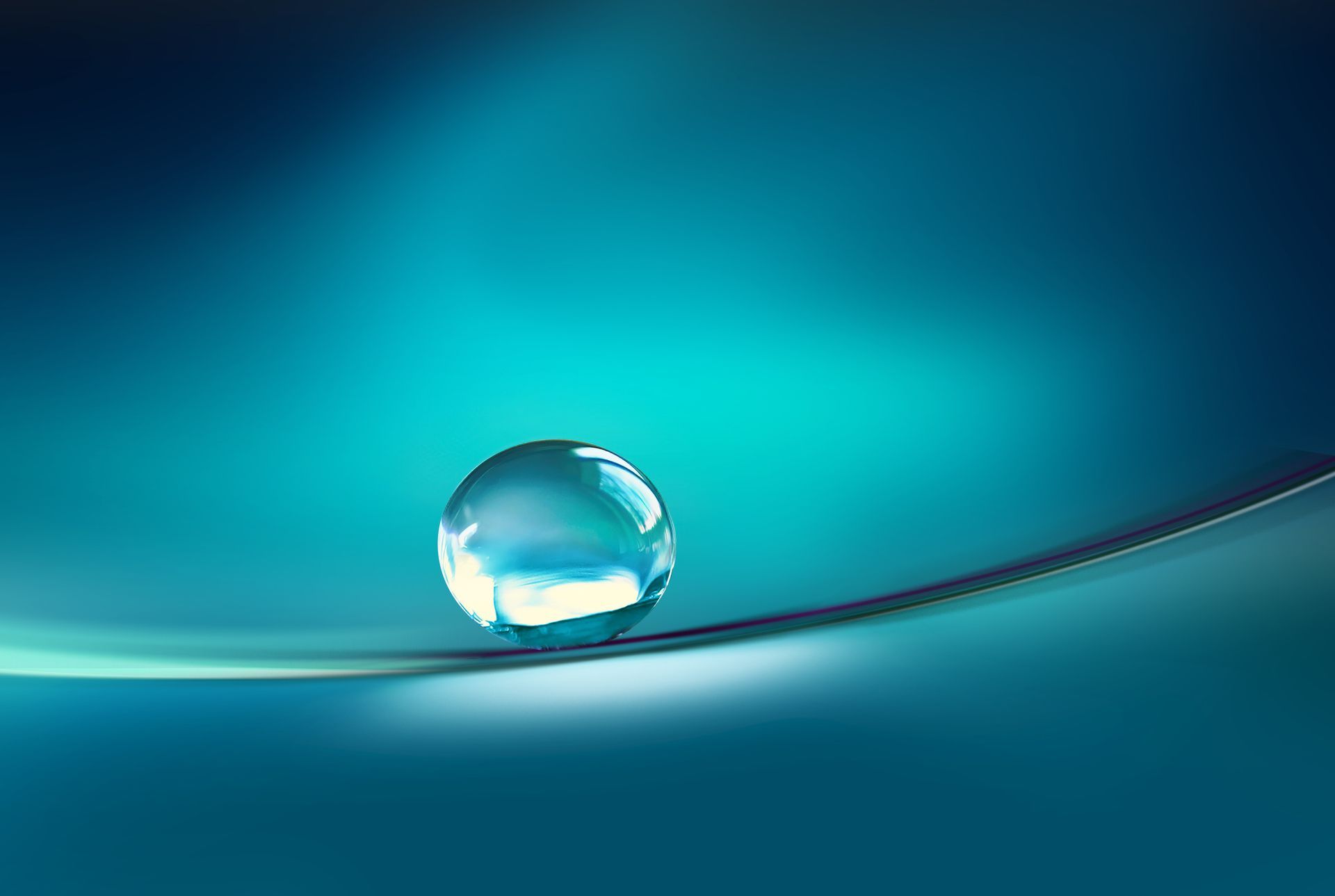 Eine Nahaufnahme eines Wassertropfens auf einer blauen Oberfläche.