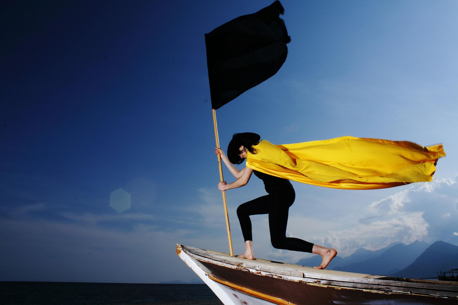 Eine Frau hält eine schwarze Flagge an der Seite eines Bootes.