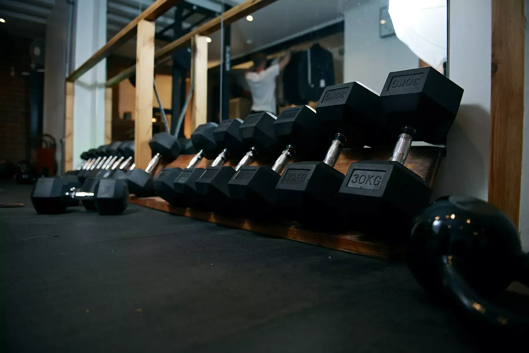 A row of dumbbells are lined up in a gym.
