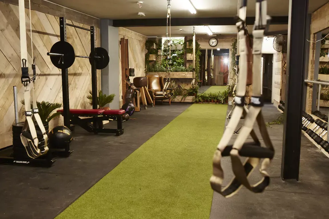A gym with a green carpet and a lot of equipment at Terra Hale, London