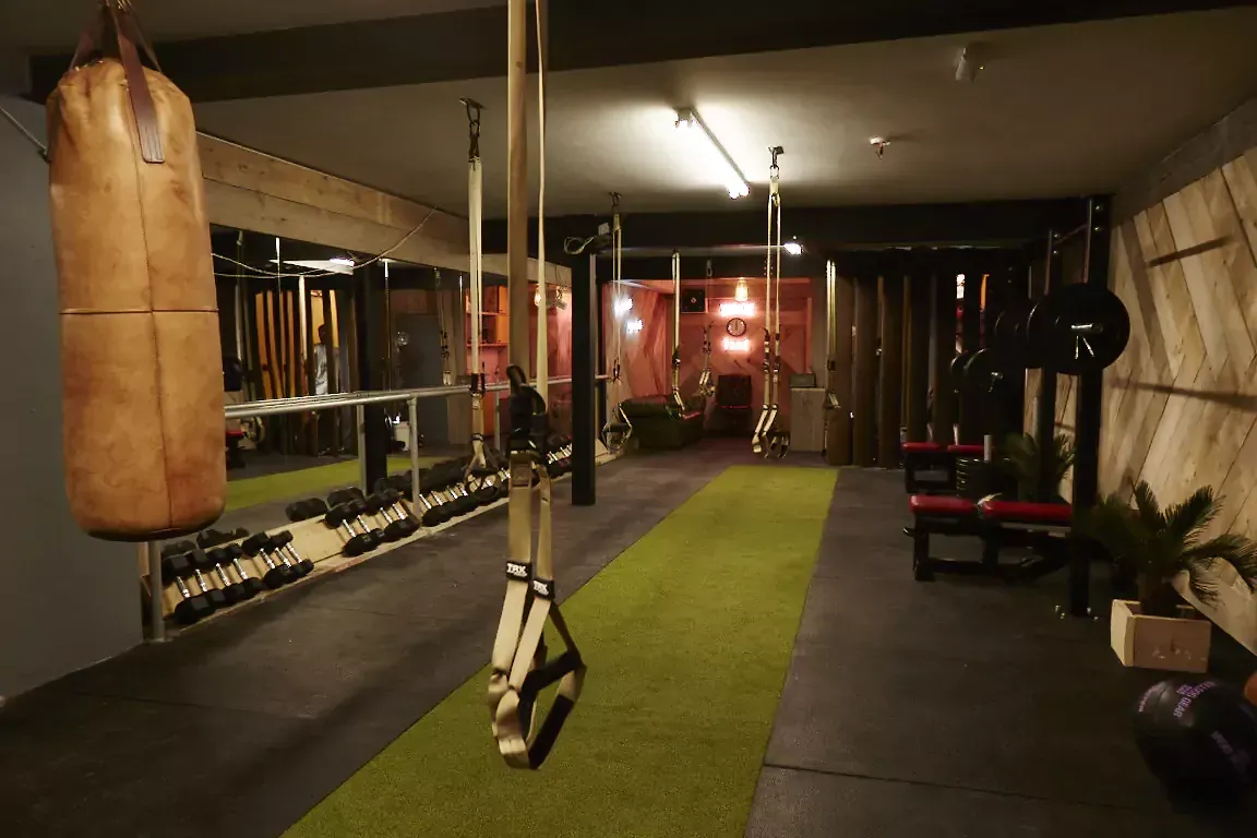 A boxing bag is hanging from the ceiling in a gym.