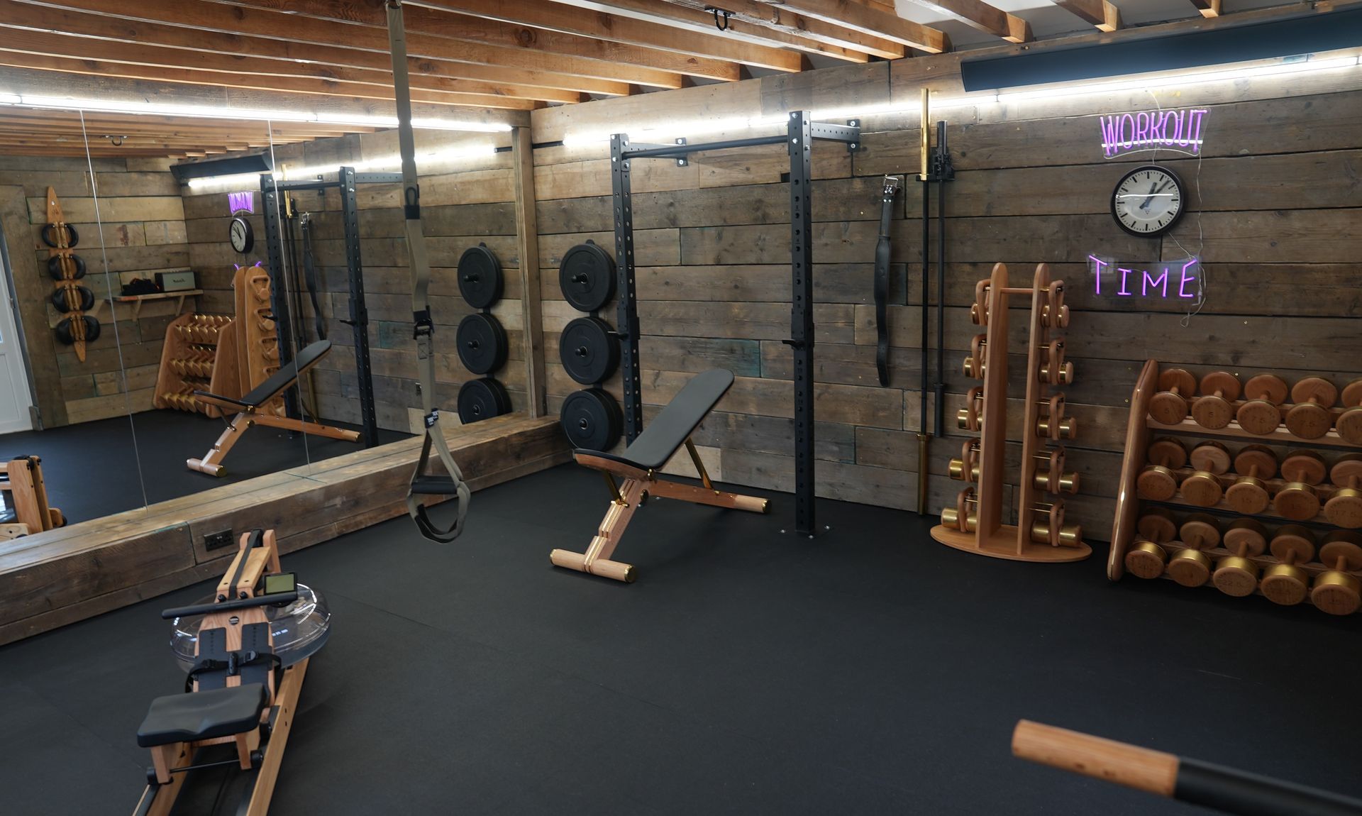 A gym with a lot of equipment and a large mirror.