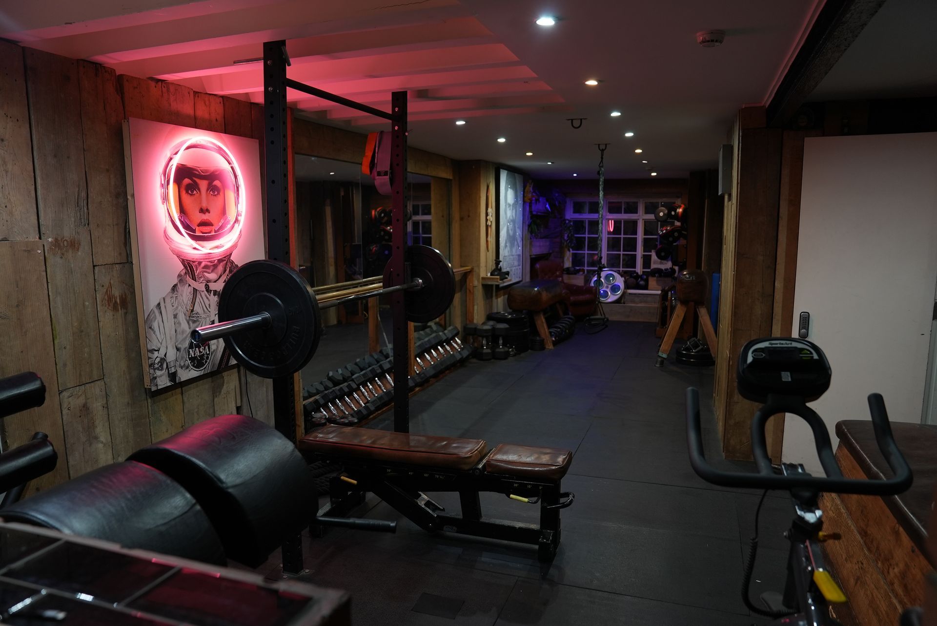 Terra Hale: A gym with a neon sign on the wall and a painting on the wall.