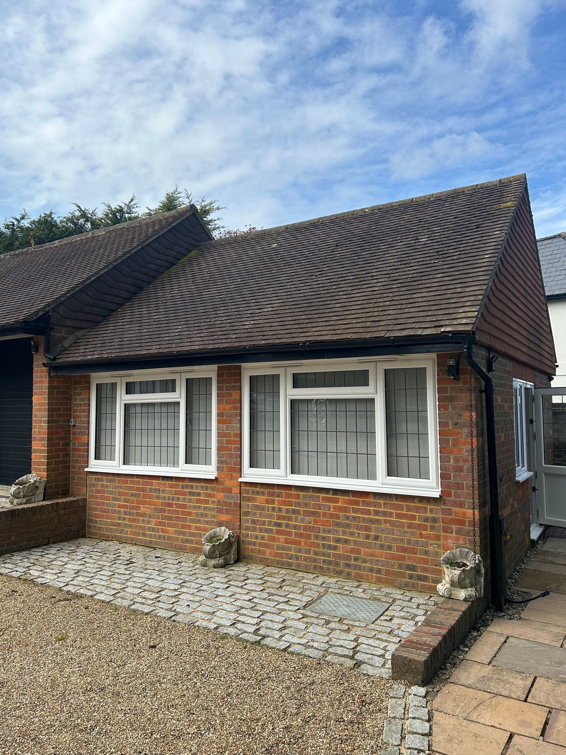 Terra Hale: A small brick house with a brown roof and white windows