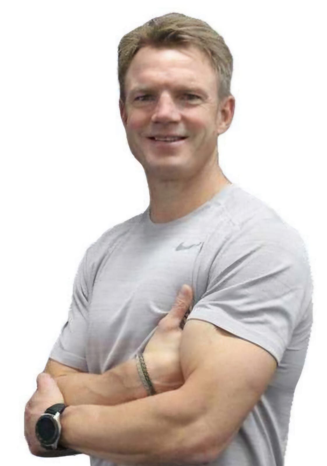 Man with fair skin wearing a gray t-shirt, arms crossed, smiling.
