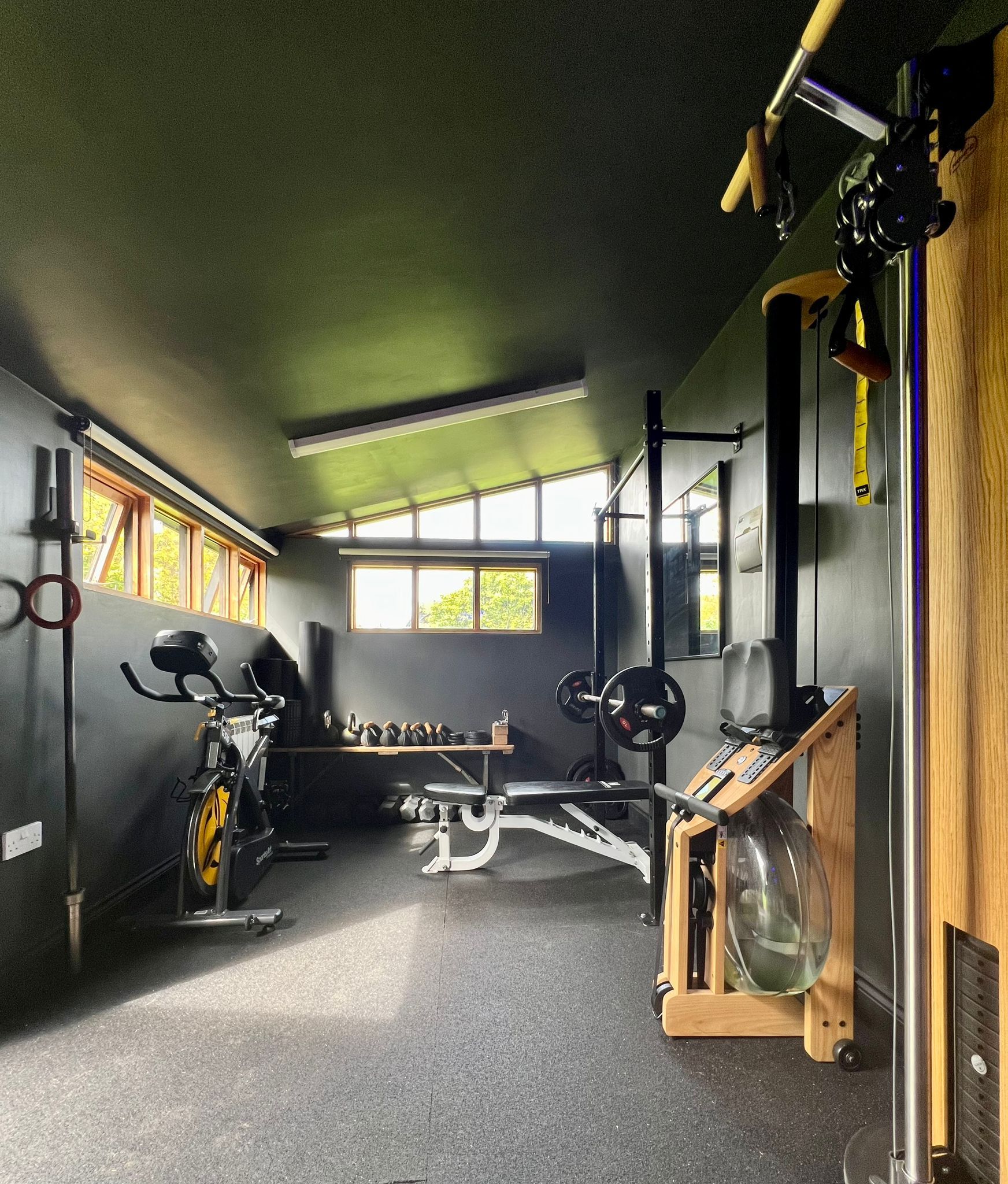 A gym with wooden walls and a rowing machine