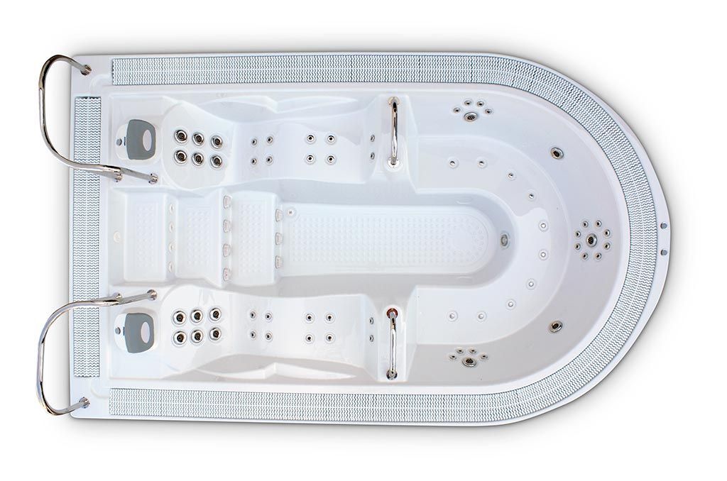 Vista aérea de un spa de natación blanco con detalles en gris, que incluye chorros y áreas para sentarse.