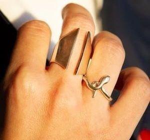 Un primer plano de la mano de una persona con dos anillos.