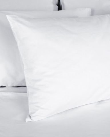Dos coixins blancs estan asseguts a sobre d'un llit.