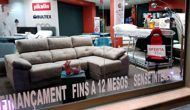 Un sofà s'exhibeix en un aparador de botiga que diu