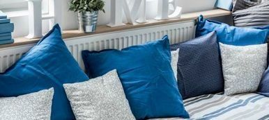 Un sofà ple de coixins blaus i blancs en una sala d'estar.