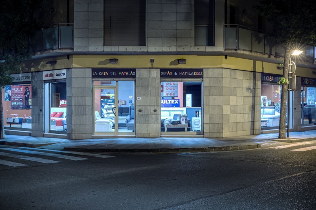 Una façana de botiga a la cantonada d'un carrer a la nit.