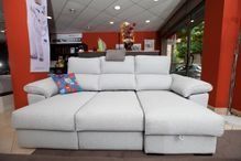 Un sofà seccional blanc amb una chaise longue en una sala d'estar.