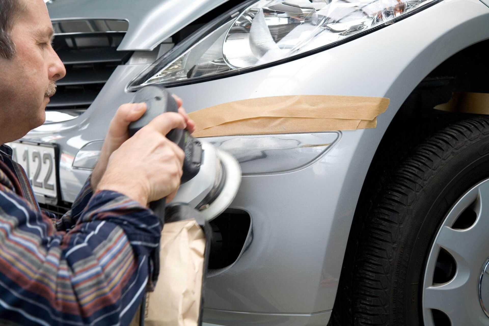 Trio Automobiltechnik GmbH Person schleift Lack eines Autos ab