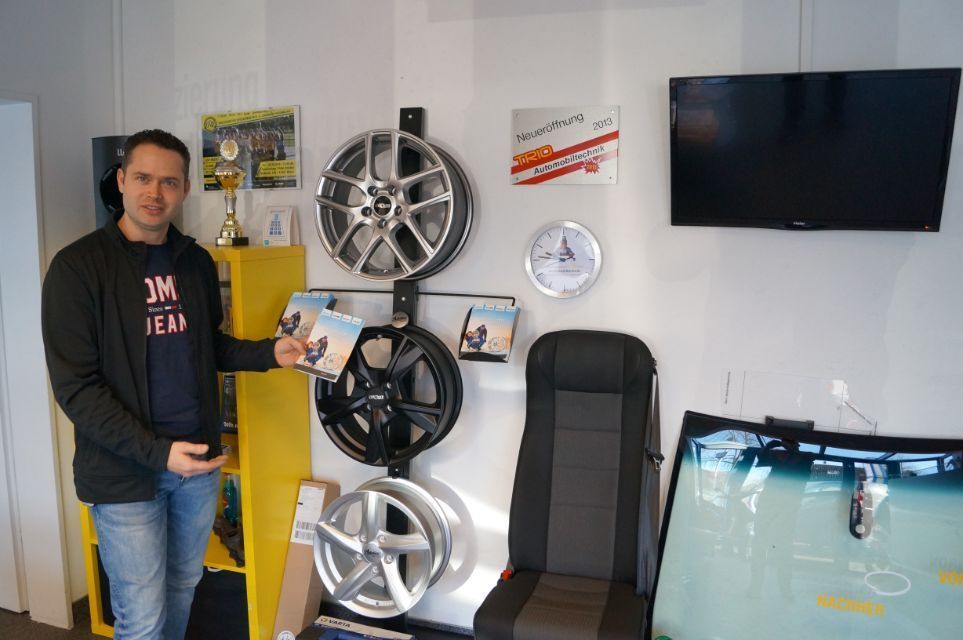 Trio Automobiltechnik GmbH Mann steht vor Autofelgen