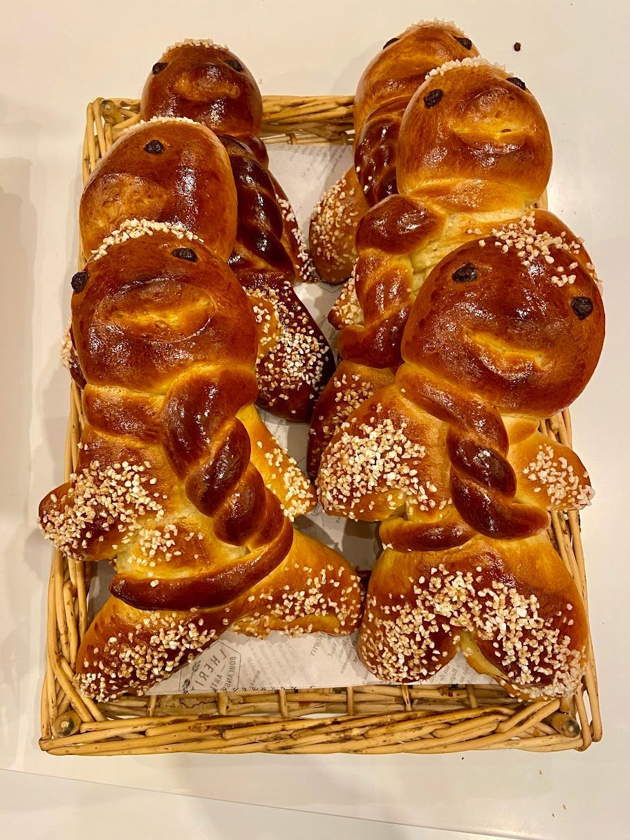 Panier de figurines en pâte à brioche brillantes et dorées aux visages souriants.