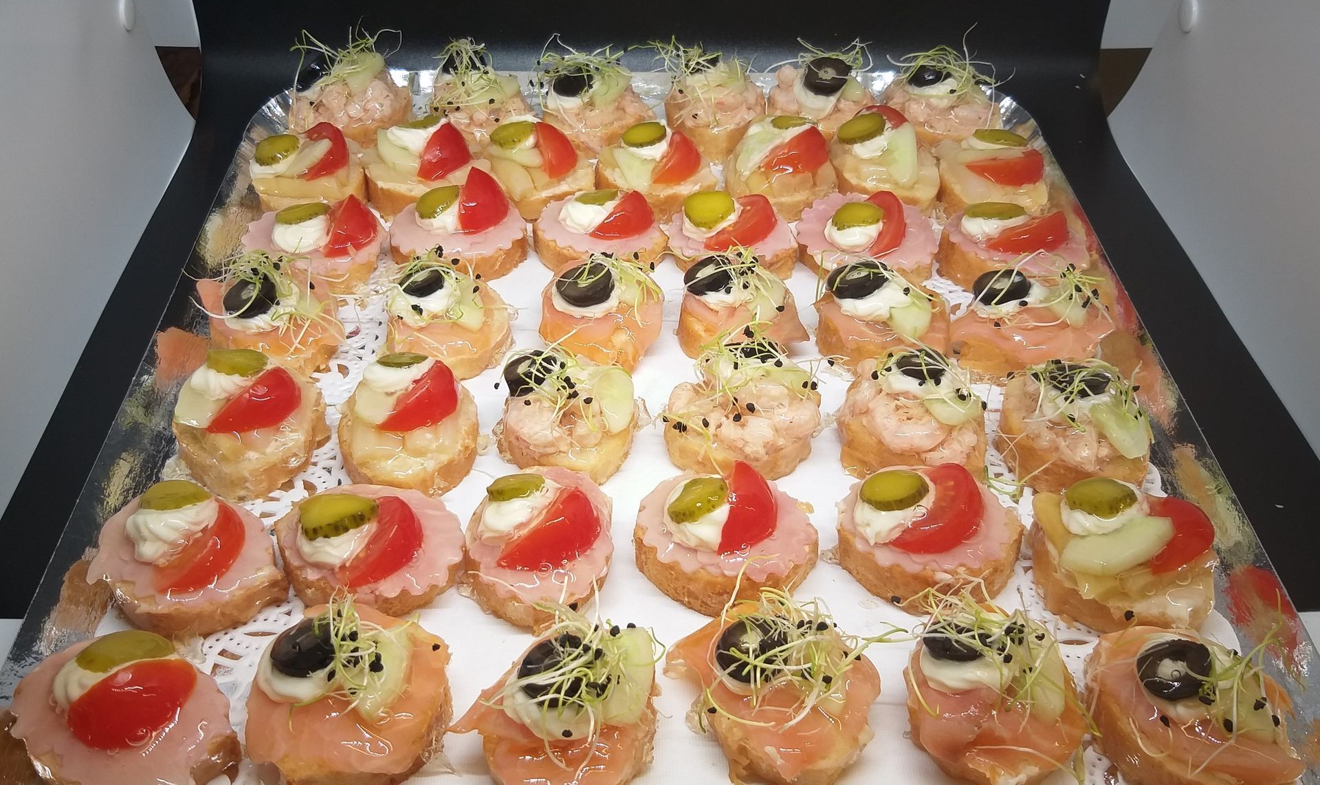 Plateau de canapés : saumon, jambon, tomate, olive, cornichon, pousses. Présentoir d'amuse-gueules.