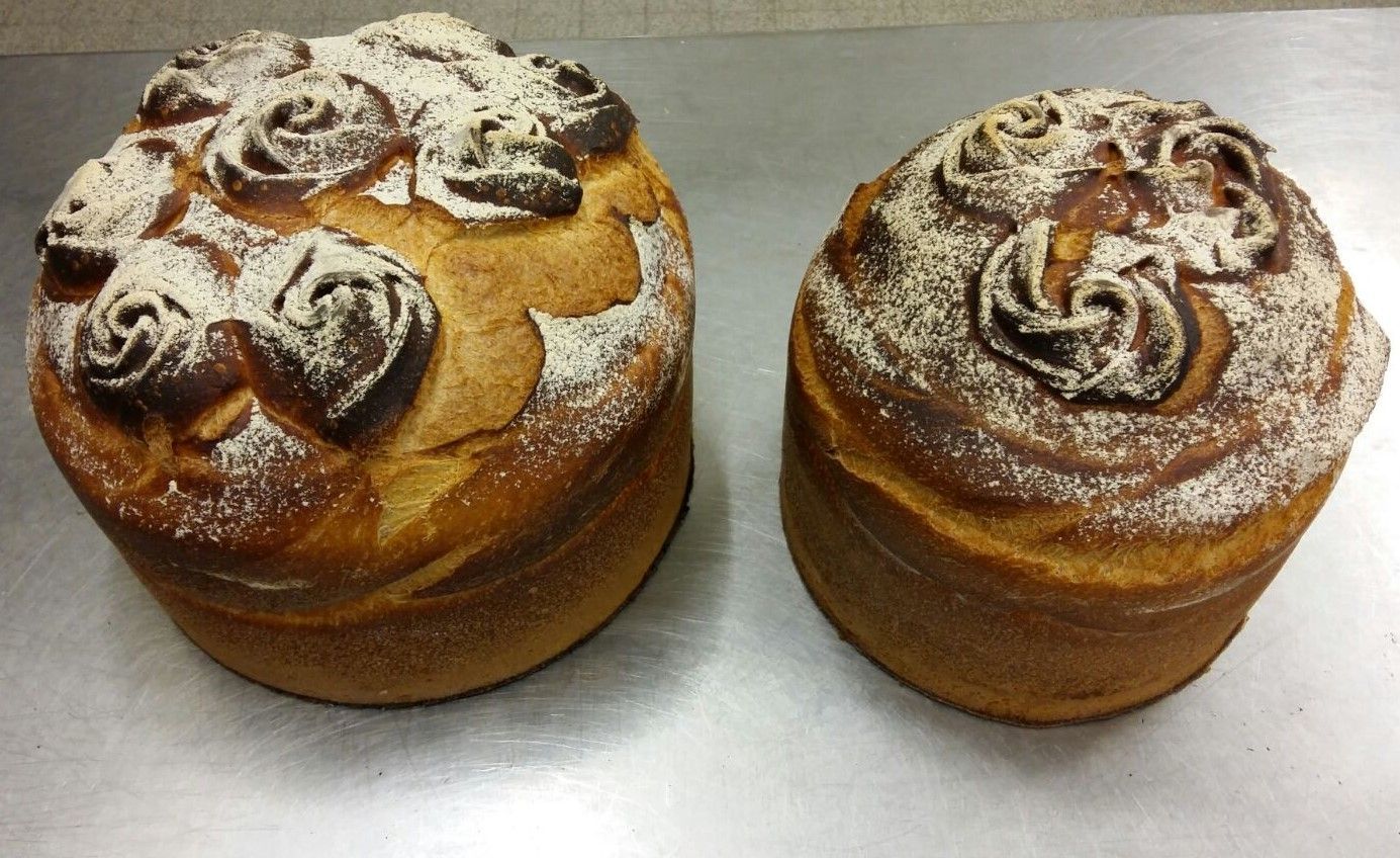 Deux viennoiseries de style brioche garnies de chocolat en forme de rose et saupoudrées de sucre glace.