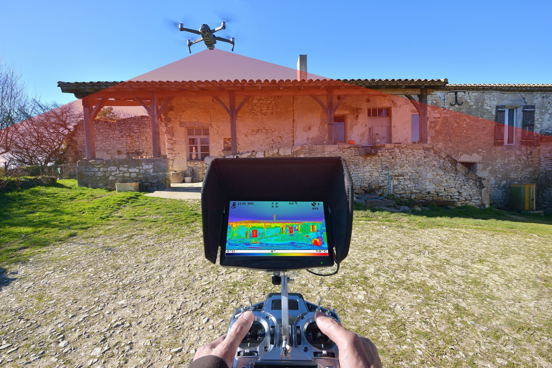 Un drone au-dessus d'une maison piloté avec un appareil équipé d'un écran