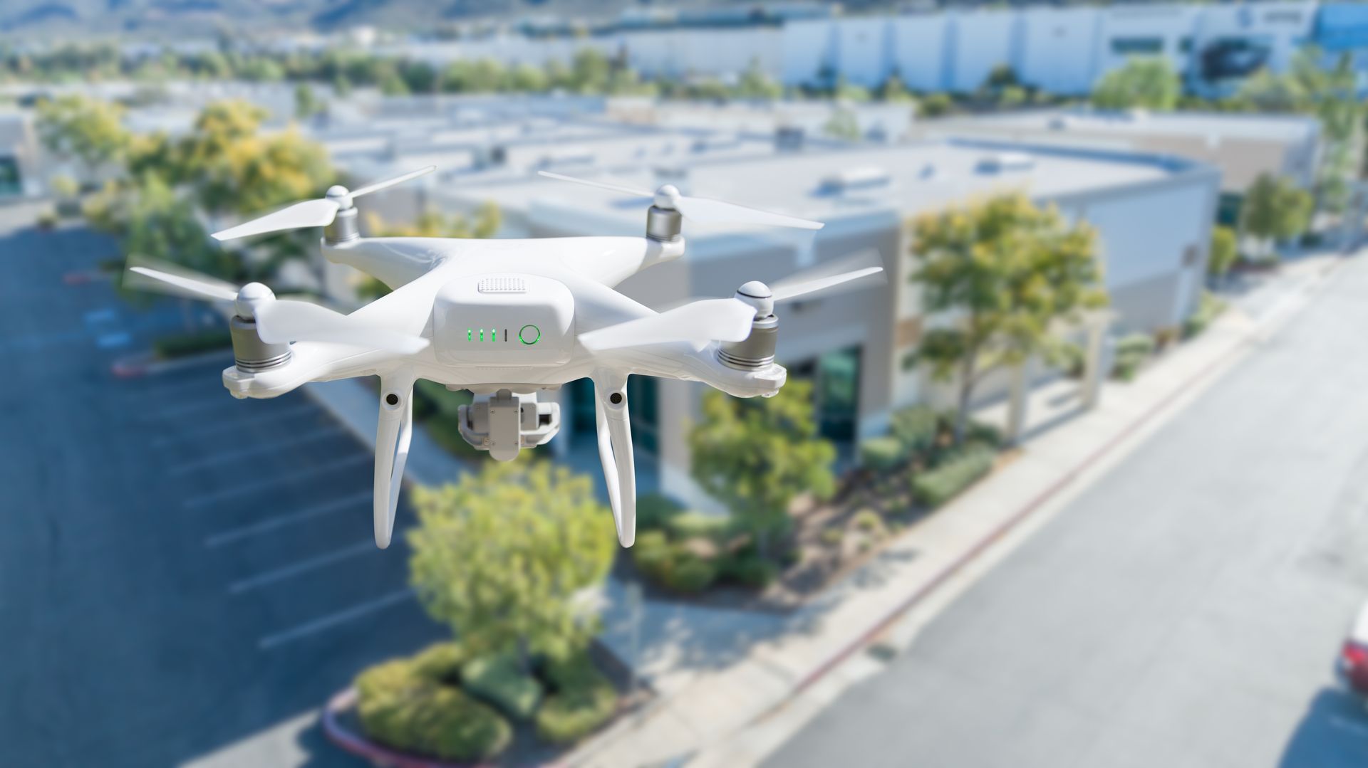 Un drone blanc qui survole un quartier