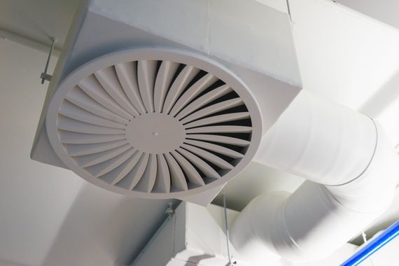 Hand mit Fernsteuerung und Klimaanlage