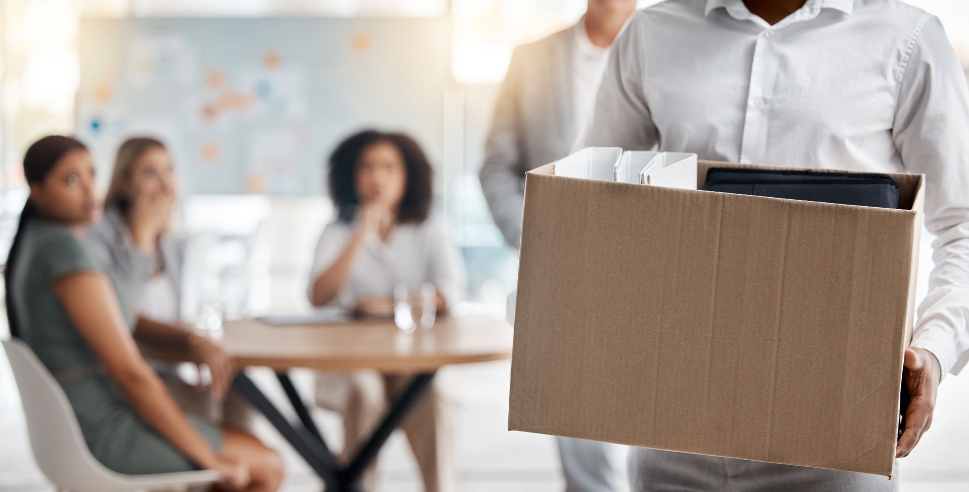 Une personne licenciée qui porte un carton