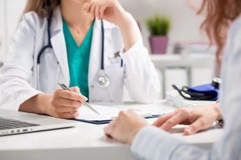 Un médico está sentado en un escritorio hablando con un paciente.