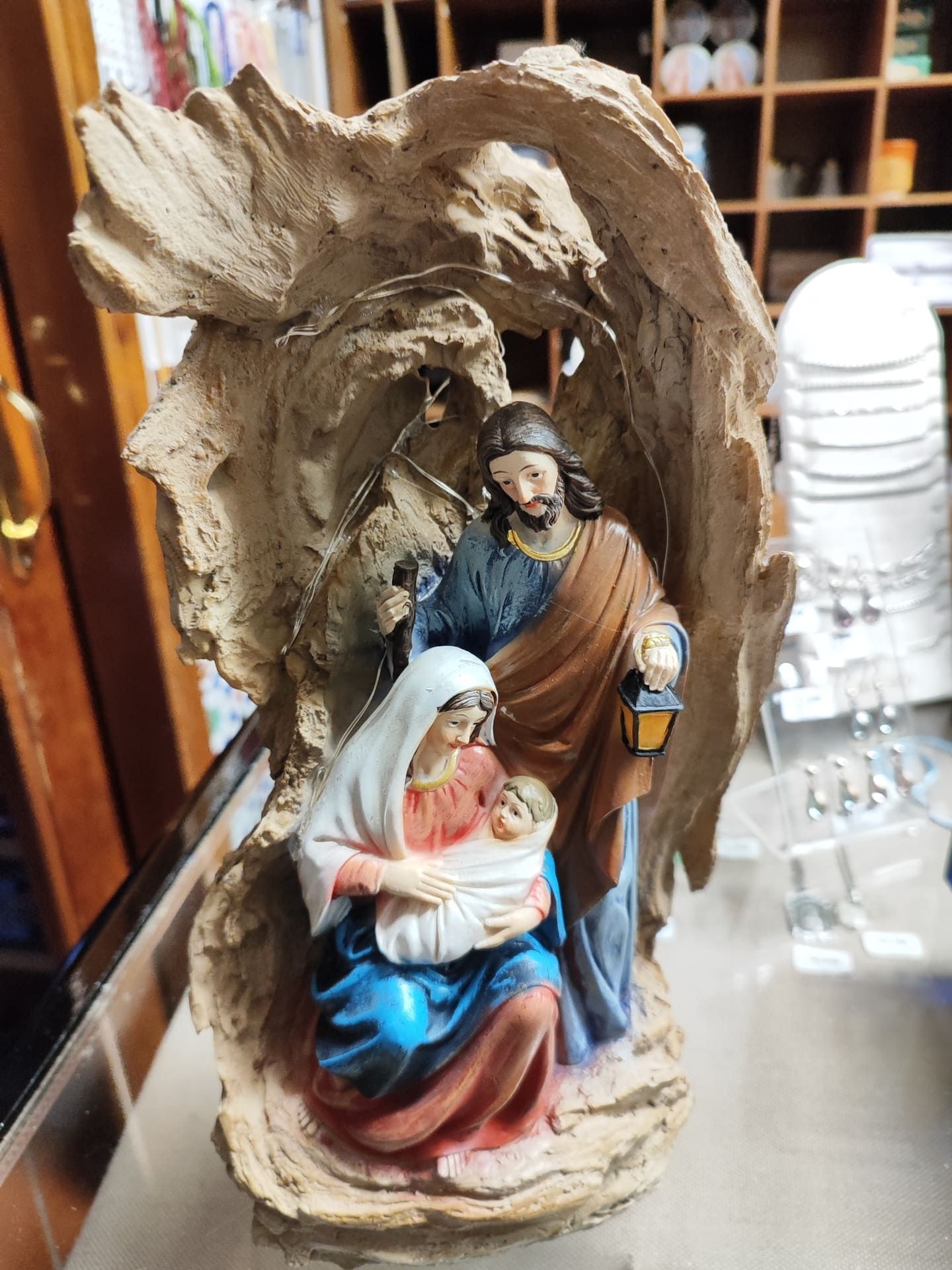 Una estatua de la sagrada familia está sentada sobre una mesa.