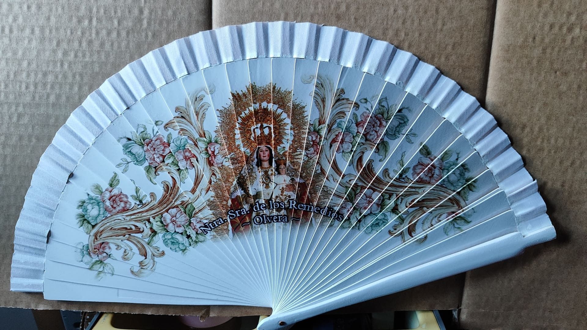 Un abanico blanco con un diseño floral.