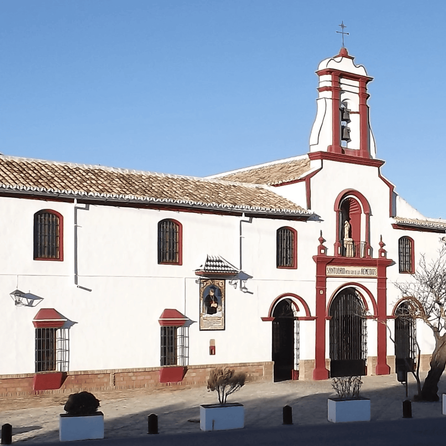 Un edificio blanco con detalles rojos y un campanario.