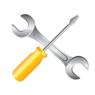 Una llave inglesa y un destornillador cruzados uno sobre el otro sobre un fondo blanco