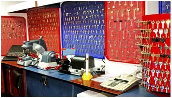 Banco de trabajo de taller con llaves colgadas en paneles perforados rojos y azules y maquinaria sobre el mostrador.