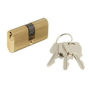 Cilindro de cerradura de puerta de latón con un juego de llaves plateadas sobre un fondo blanco.