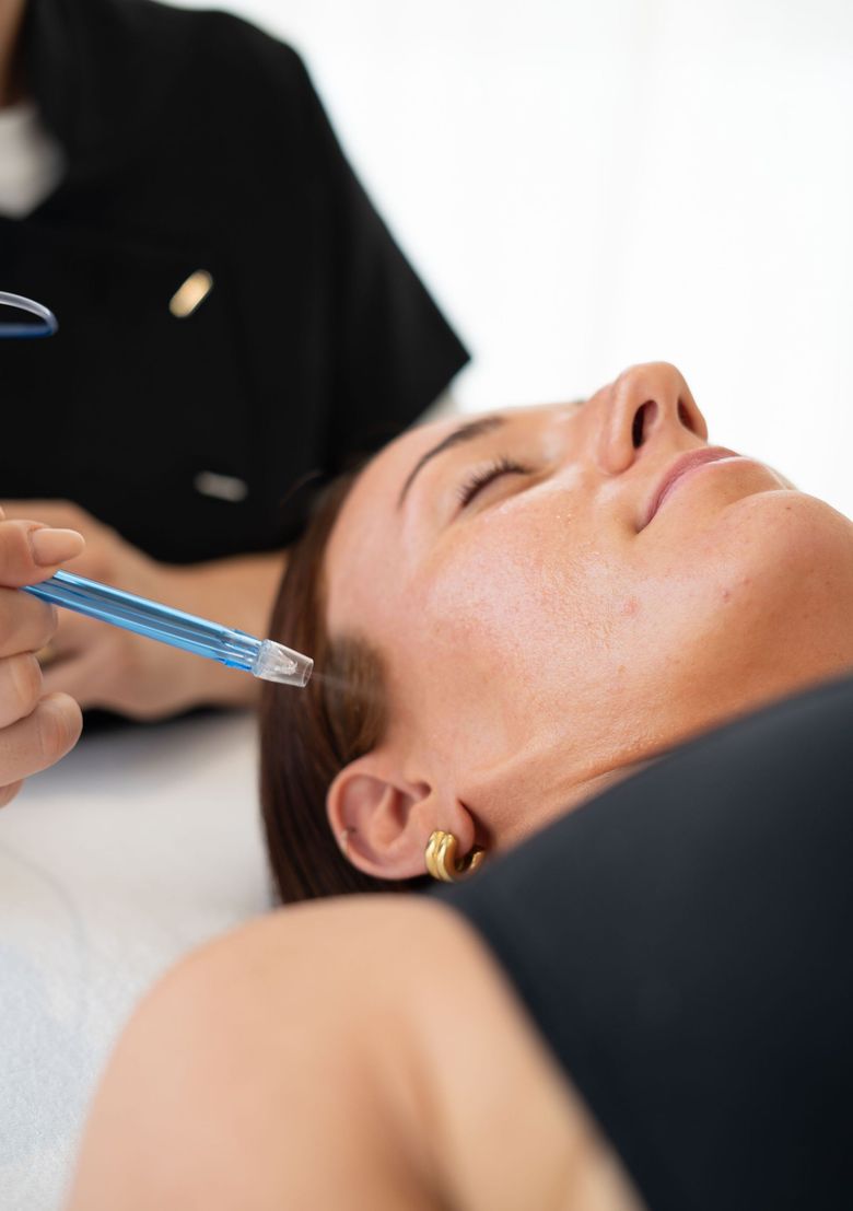 Soin du visage au pinceau sur une cliente allongée dans un spa