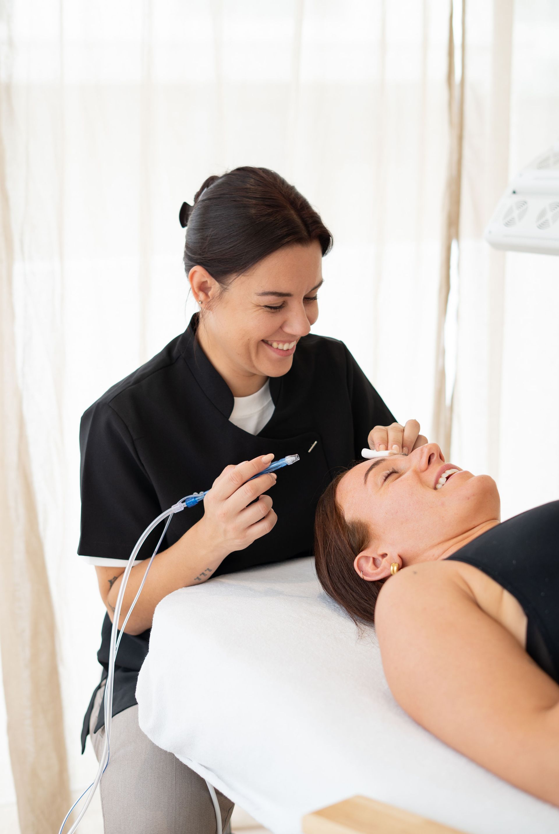 Un dentiste utilise un instrument dentaire tandis qu’un patient souriant est allongé sur un fauteuil de soins