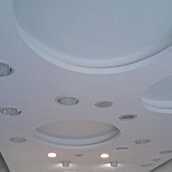 Techo con grandes paneles redondos empotrados y pequeñas luces en un interior moderno.